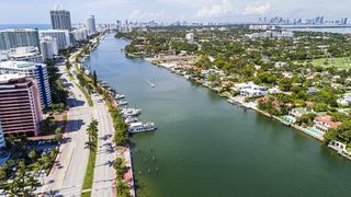 Miami Beach, Florida, aerial view, Indian Creek La Gorce Island Country Club, waterfront mansions estates homes and city skyline.